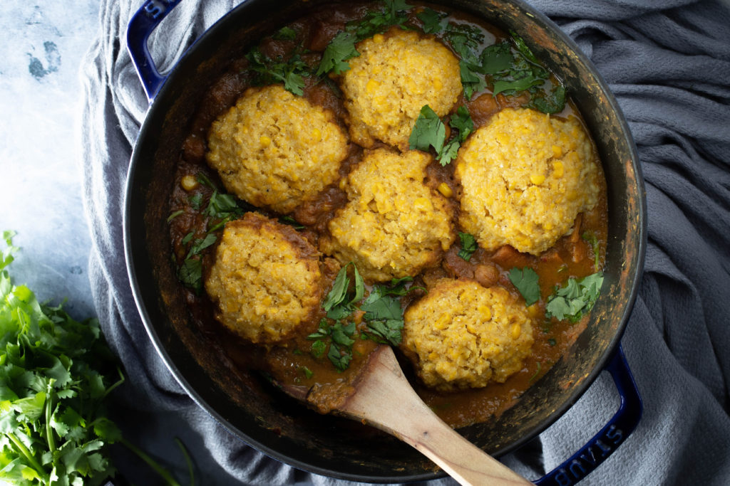 corn dumplings on top of a pot of massaman curry